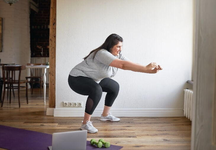 Woman doing squats on a yoga mat