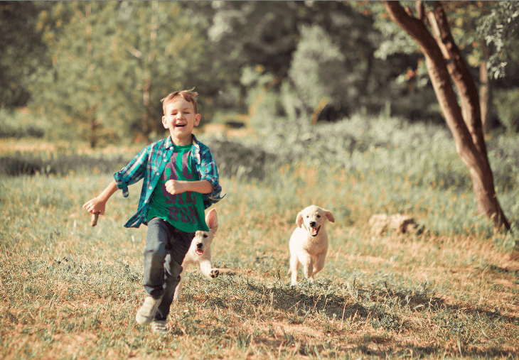 boy running outside with puppy