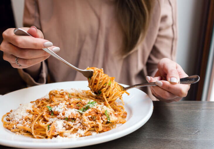 woman twirling spaghetti on a plate
